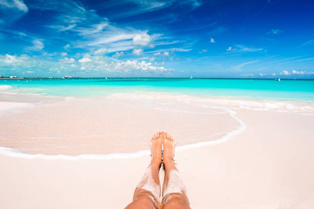 Closeup female feet on white sand beach