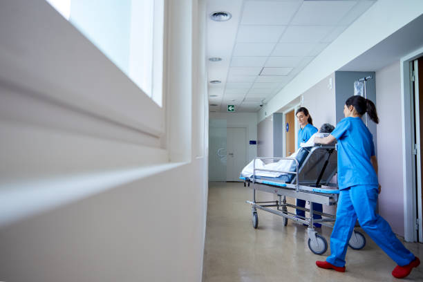 istock Two nurses move a patient on a hospital gurney. 1232334578