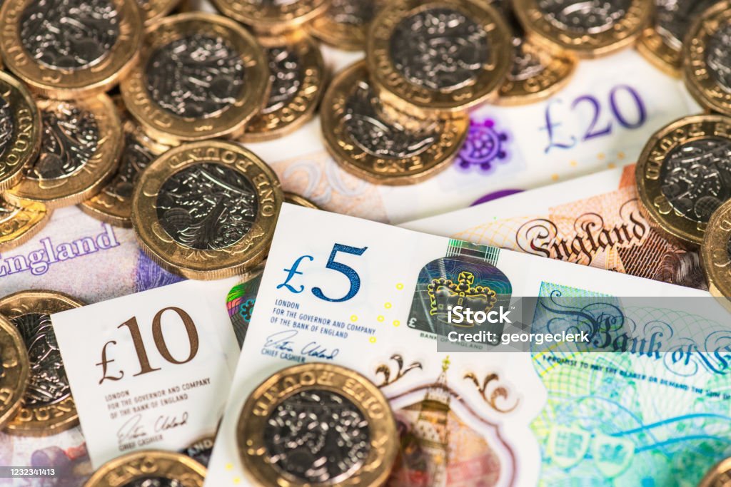 Modern British currency Recently issued UK £5, £10 and £20 polymer banknotes with £1 coins. Currency Stock Photo