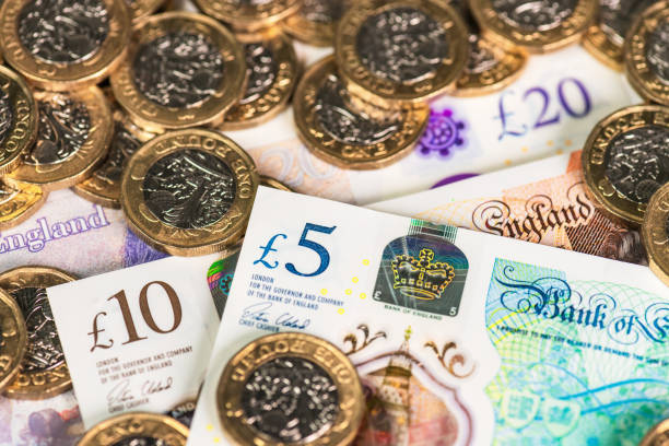 Modern British currency Recently issued UK £5, £10 and £20 polymer banknotes with £1 coins. british currency stock pictures, royalty-free photos & images
