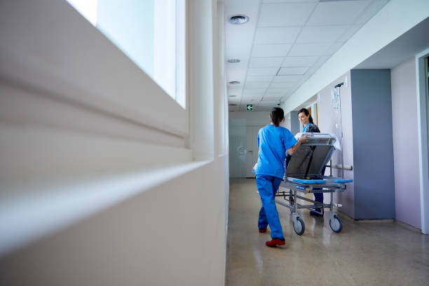 istock Two nurses move a patient on a hospital gurney. 1232342897