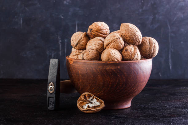 istock Walnut in a clay bowl and a gout on a concrete background 1232343954