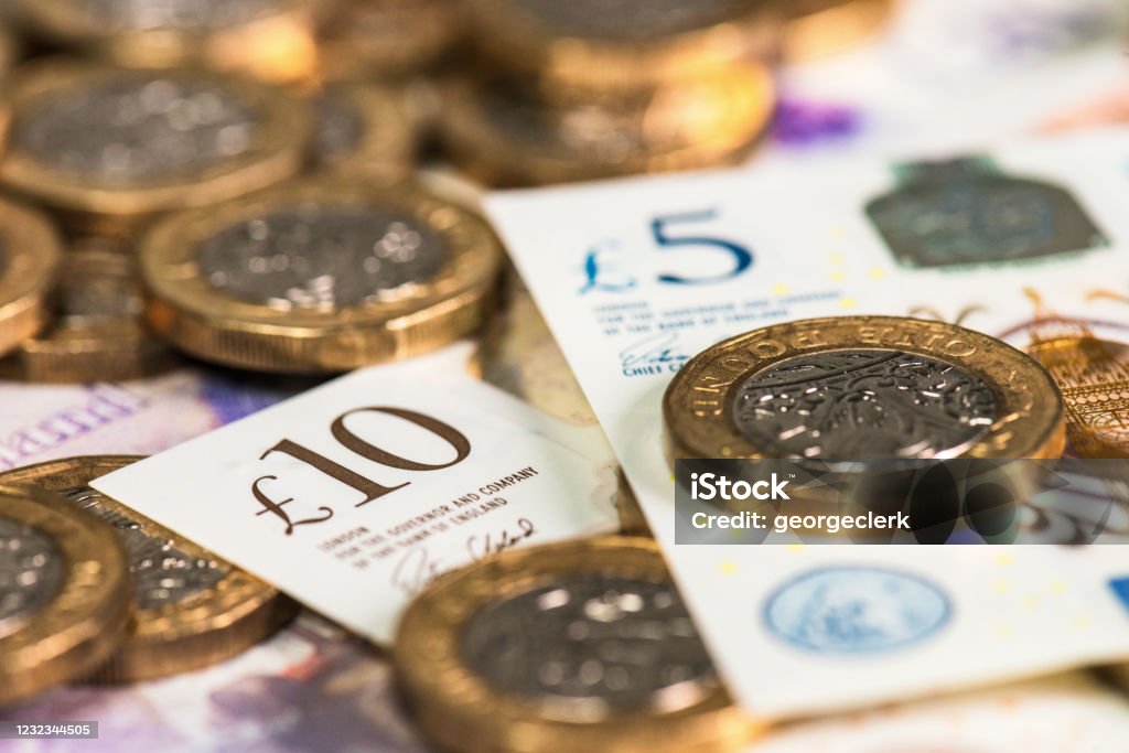 Close up of new UK currency Recently issued British polymer ten and five pound notes, with pound coins. British Currency Stock Photo