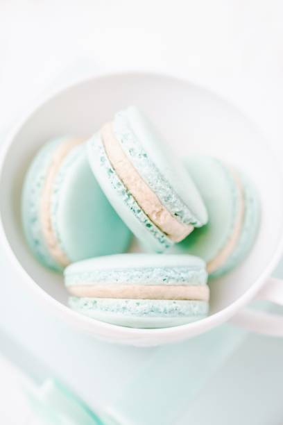 istock Mint or tiffany color macaron or macaroon dessert with vanilla cream in white cup. Copy space 1232350006