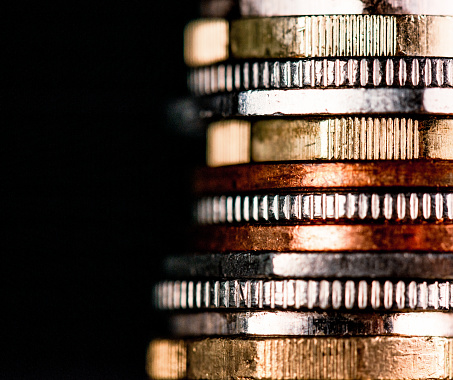 Close-up of a mixture of UK coins, with a low-key exposure, against a black background.