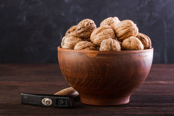 istock Walnut in pottery and hammer on a wooden table 1232360167