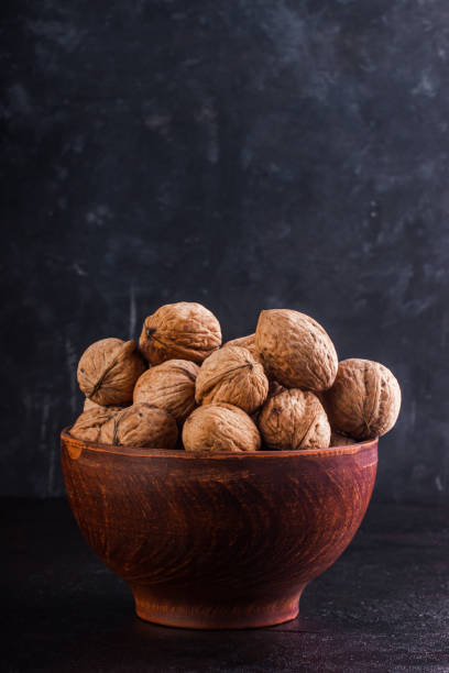 istock Full clay bowl with walnut on a dark background. Copy space. 1232360172