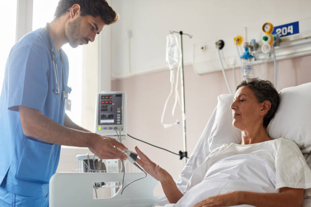 istock One male nurse measuring a patient's pulse. 1232408040