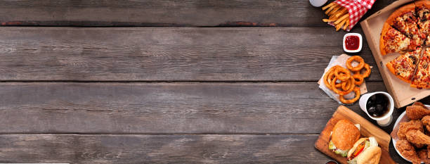 istock Assorted take out and fast foods, top down view side border on a dark wood banner background 1232409809