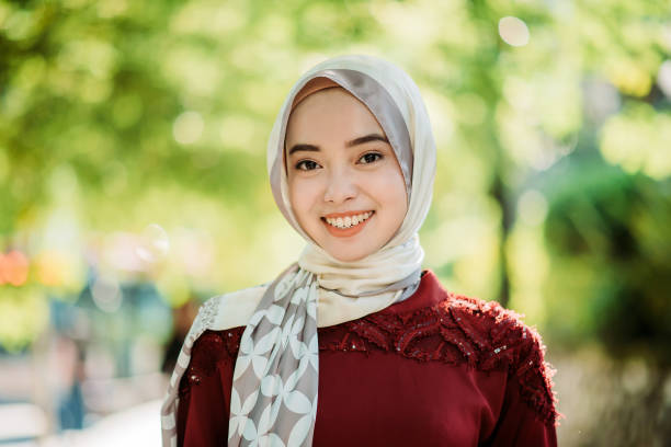 Portrait of an asian young malay hijab female happy with toothy smile and looking at camera stock photo