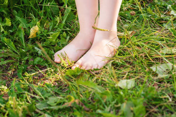 istock Barefoot of child standing on green grass. 1232444584