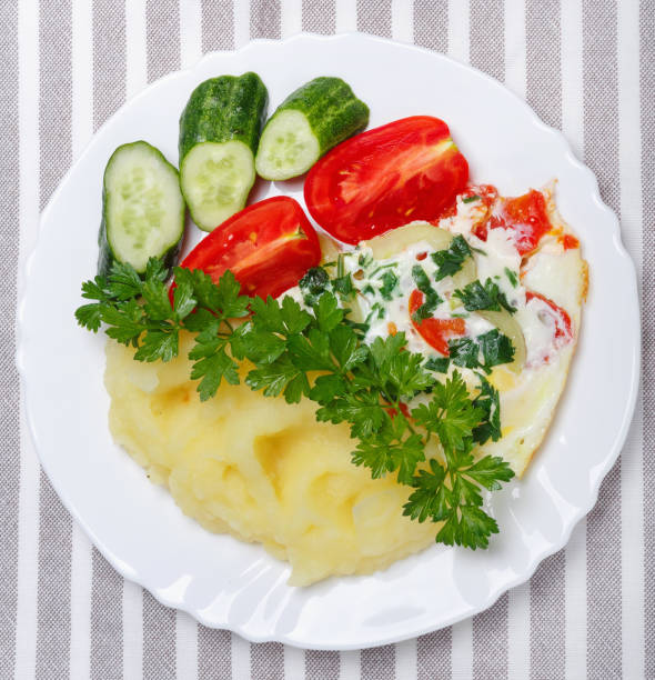 istock Hot tasty mashed potatoes with scrambled eggs, tomatoes, cucumbers and fresh parsley in  plate 1232470751