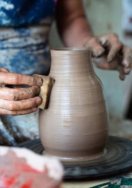 istock Potter hands making in clay on pottery wheel. Potter makes on the pottery wheel 1232529677
