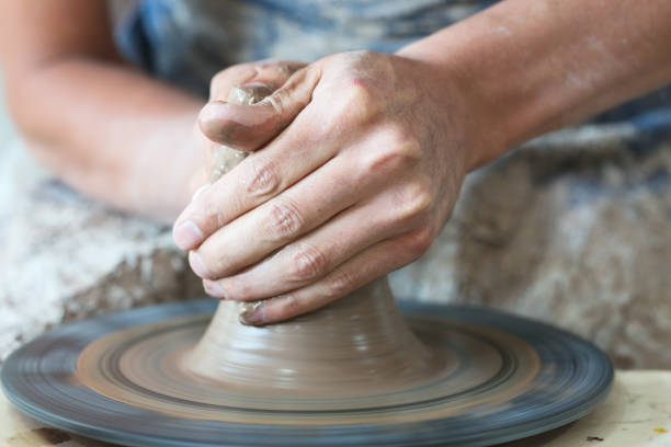 istock Potter hands making in clay on pottery wheel. Potter makes on the pottery wheel 1232532243