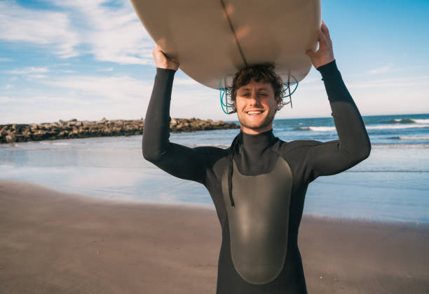 istock Young surfer holding up his surfboard. 1232541943
