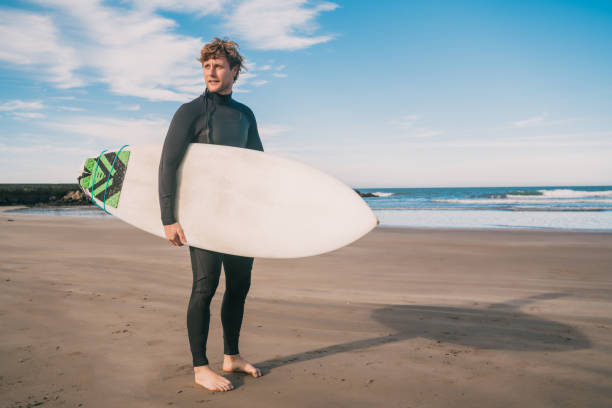 istock Surfer standing in the ocean with his surfboard. 1232542087