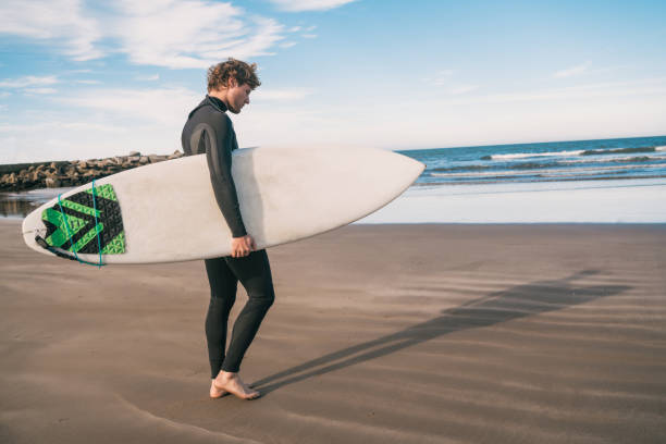 istock Surfer standing in the ocean with his surfboard. 1232542471