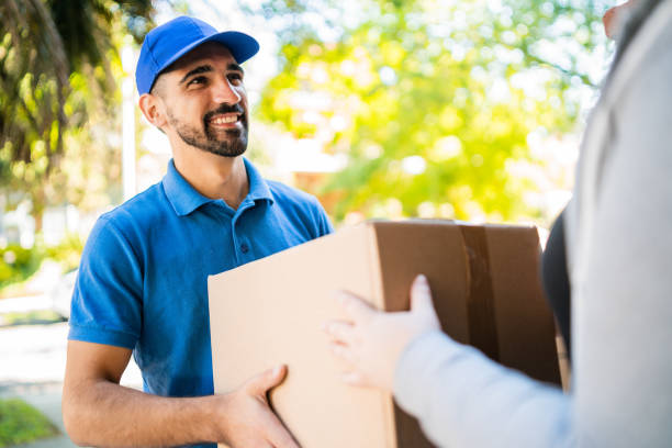 istock Delivery man carrying packages while making home delivery. 1232542898