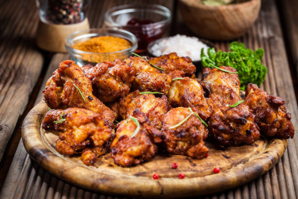 istock Hot chicken wings with different spices and dips on wooden background 1232556814