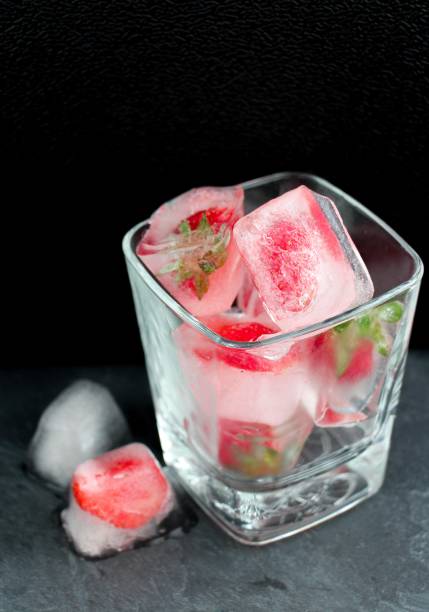istock Glass with iced strawberry on black background 1232565033