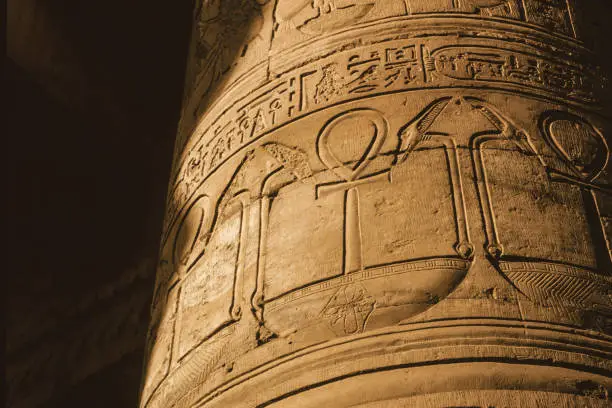 Column covered by hieroglyphics carved in bas-relief by the ancient Egyptians in a temple near Aswan. A village of enormous archaeological significance next to the Nile River in southern Egypt.