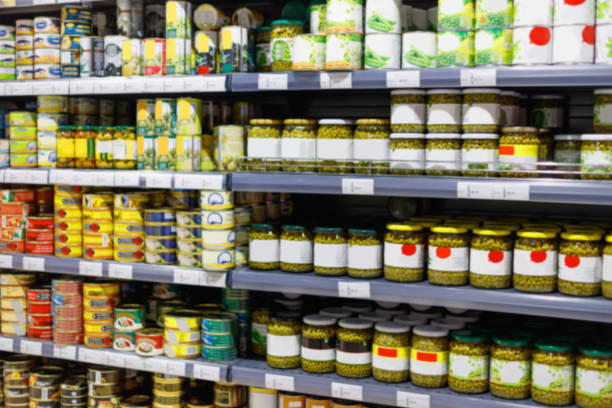 Interior view canned food products in cold storage store. Blurred interior view canned food products in cold storage grocery store. grocery shelf cans stock pictures, royalty-free photos & images