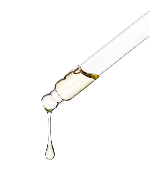 Cosmetic dropper with yellow oil. Glass dropper isolated on a white background. Path saved. Cosmetic dropper with yellow oil. Glass dropper isolated on a white background. Path saved. face serum stock pictures, royalty-free photos & images