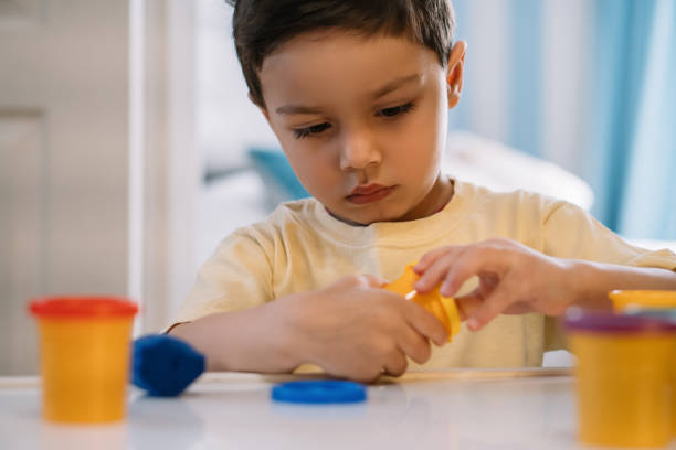 istock selective focus of attentive, adorable boy opening container with  plasticine 1232598919