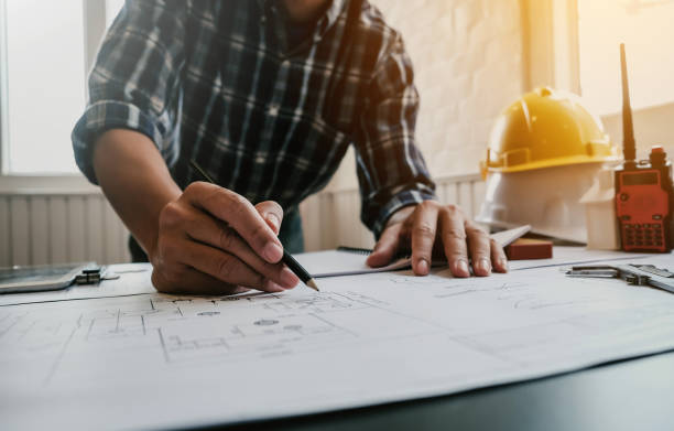 Male architect or engineer working at home drawing the construction project. Male architect or engineer working at home drawing the construction project. council flat stock pictures, royalty-free photos & images