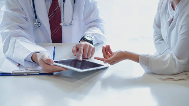 istock Doctor and female patient discussing while using digital tablet at hospital. 1232628299