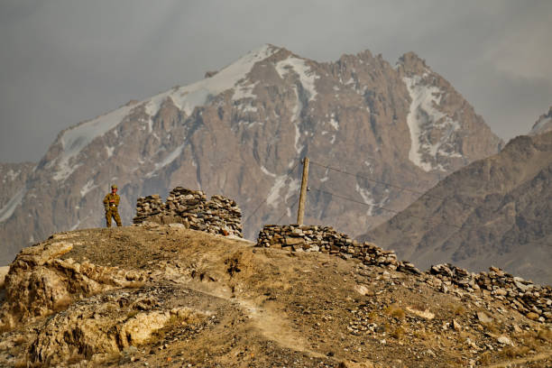 Namadgut. Tajikistan. August 09, 2019. Ancient khaakha fortress on the coast of the Panj river. An armed border guard is responsible for protecting the border between Tajikistan and Afghanistan.