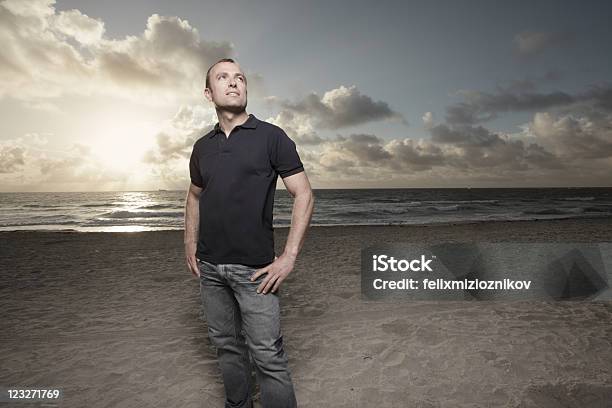 Foto de Homem Na Praia Durante O Nascer Do Sol e mais fotos de stock de Homens - Homens, Camisa Pólo, Modelo profissional