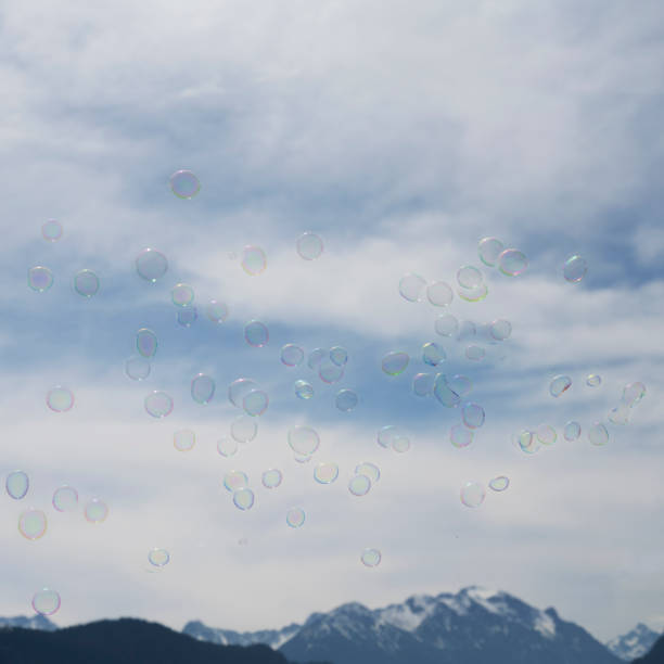 istock Many soap bubbles in front of cloudy sky and mountain chain 1232782736