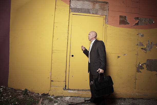 Businessman knocking on a yellow door