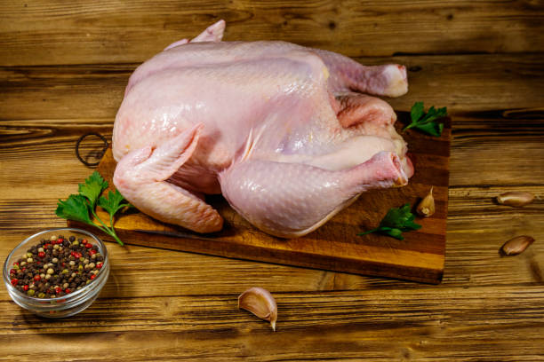 istock Raw whole chicken with spices on a wooden table 1232800723