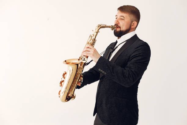 istock Man in black suit standing with a saxophone 1232859955