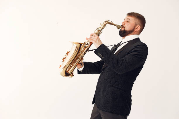 istock Man in black suit standing with a saxophone 1232860029