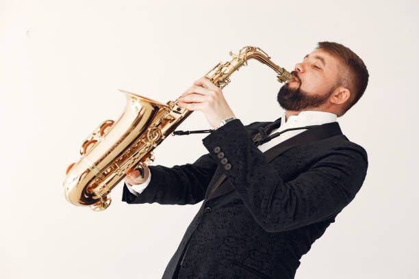 istock Man in black suit standing with a saxophone 1232860604
