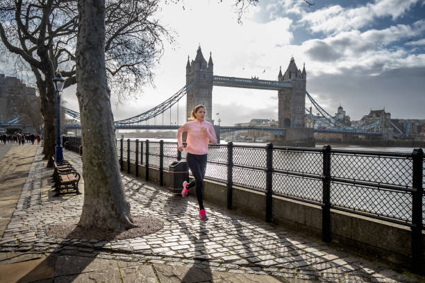 istock Young woman running by the river Thames 1232862663