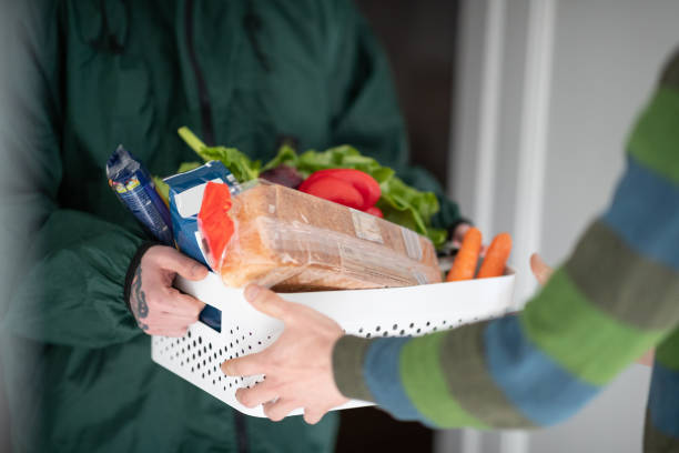 istock Courier and customer's hands holding groceries delivery in a crate 1232889050