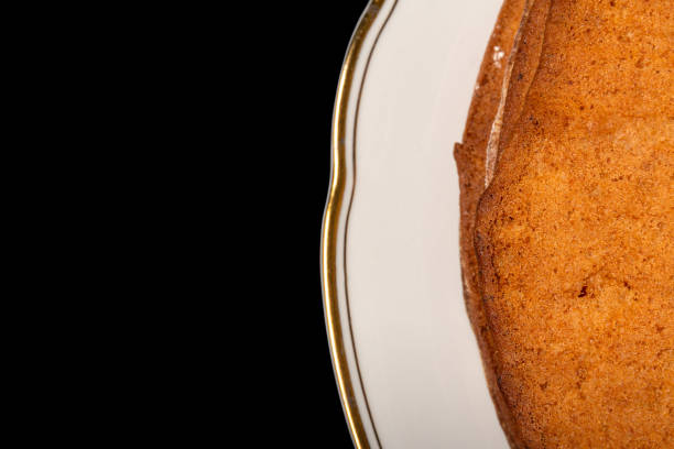 istock Golden cake on a white plate and black background 1232893619