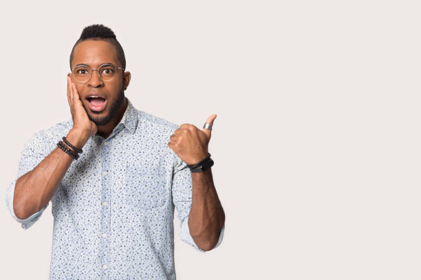 istock Amazed African American man pointing finger at copy space isolated 1232986387