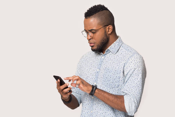 istock Serious African American man using phone isolated on white background 1232986697