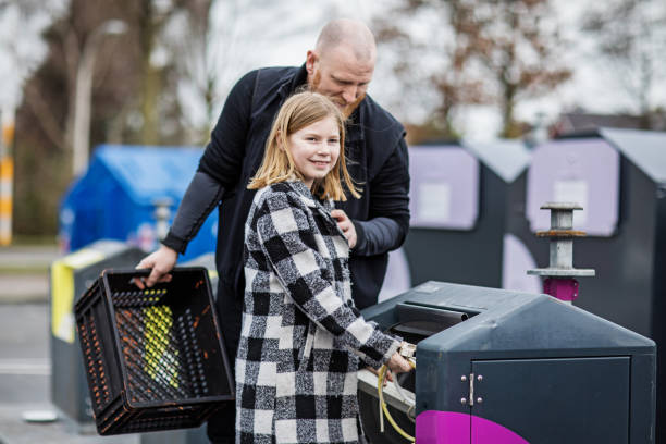 istock Father and daughter recycling trash goods 1233030590
