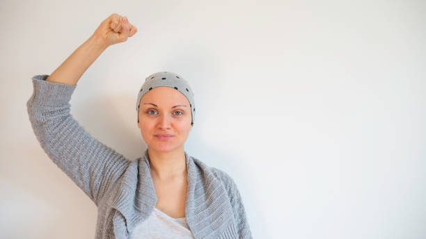 ritratto di sopravvissuta al cancro femminile senza sfondo bianco. felice sopravvissuto al cancro dopo la chemioterapia di successo. copiare lo spazio per il testo. - women standing fist success foto e immagini stock