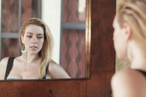 Attractive young woman glancing in the mirror