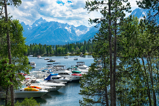 Grand Teton National Park, Wyoming, USA-July,15,2016. Beautiful  view of lake with boats and yachts docked and high mountains in the background.