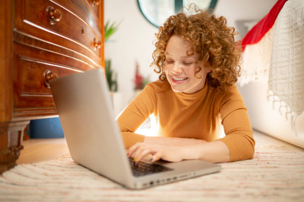 istock Young cheerful redhead woman relaxing at home using a laptop 1233074407