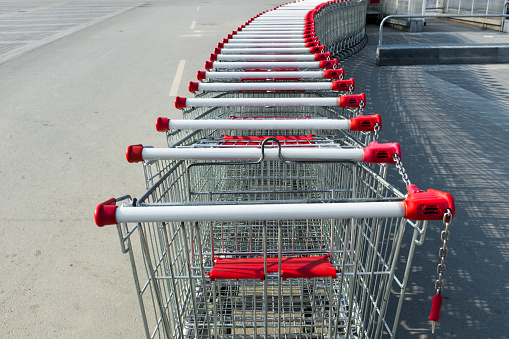 A row of shopping carts in a supermarket in a parking