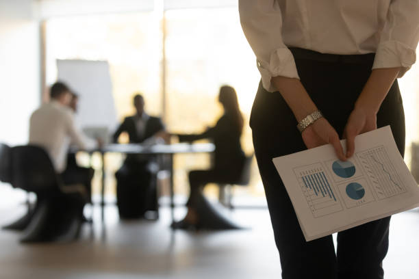 femme d’affaires de vue arrière retenant des papiers financiers prêts pour la présentation - timide photos et images de collection